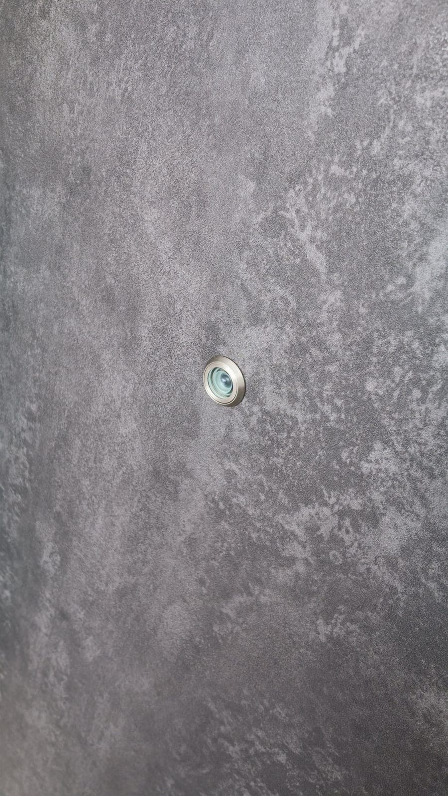 Grey stone-look film on a main door, trimmed around the door viewer