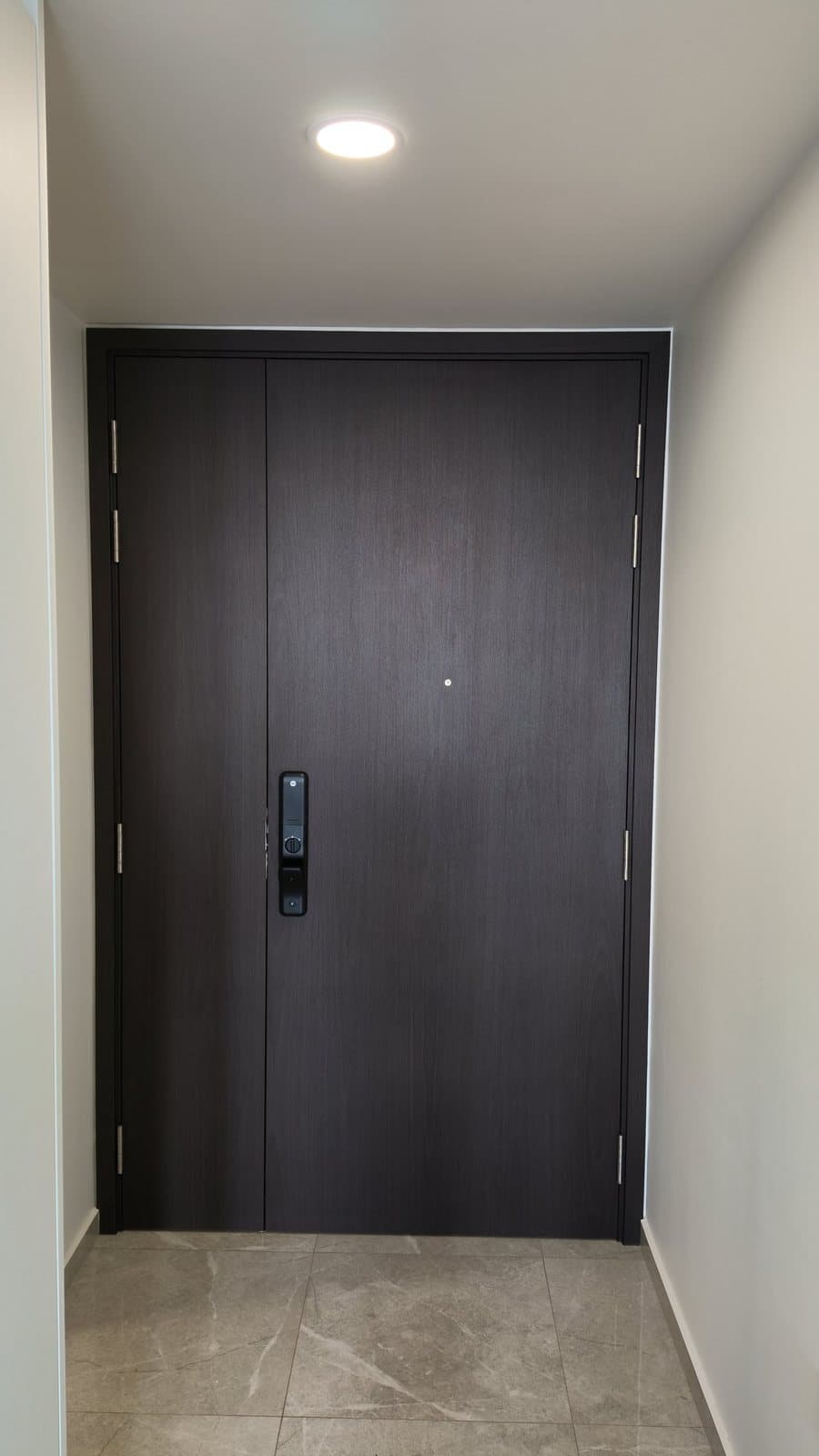 A double main door in Queenstown wrapped in a dark wood-look film