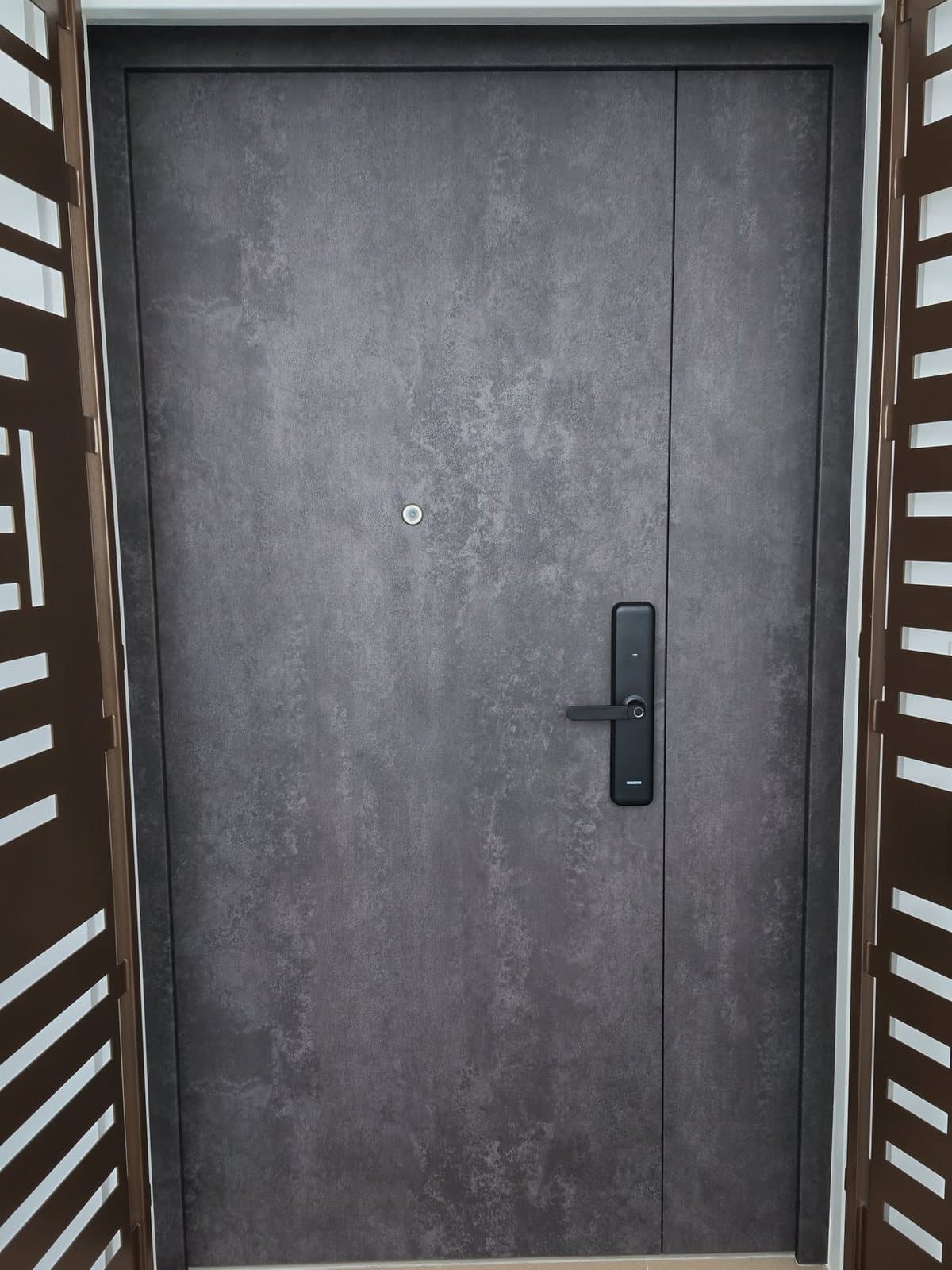 A main door in Tampines wrapped in a grey stone-look film