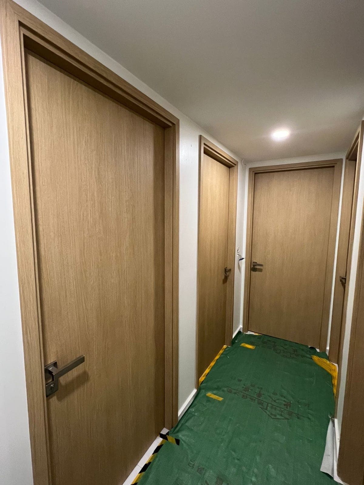Light oak bedroom doors on install day, with the floor covered