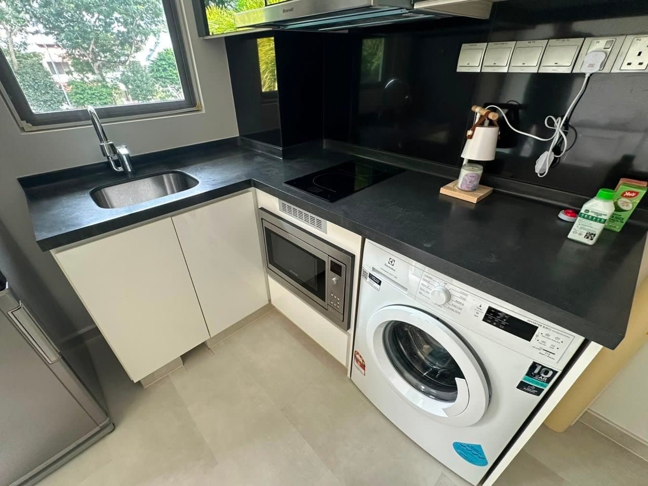 An L-shaped kitchen with a black worktop before wrapping