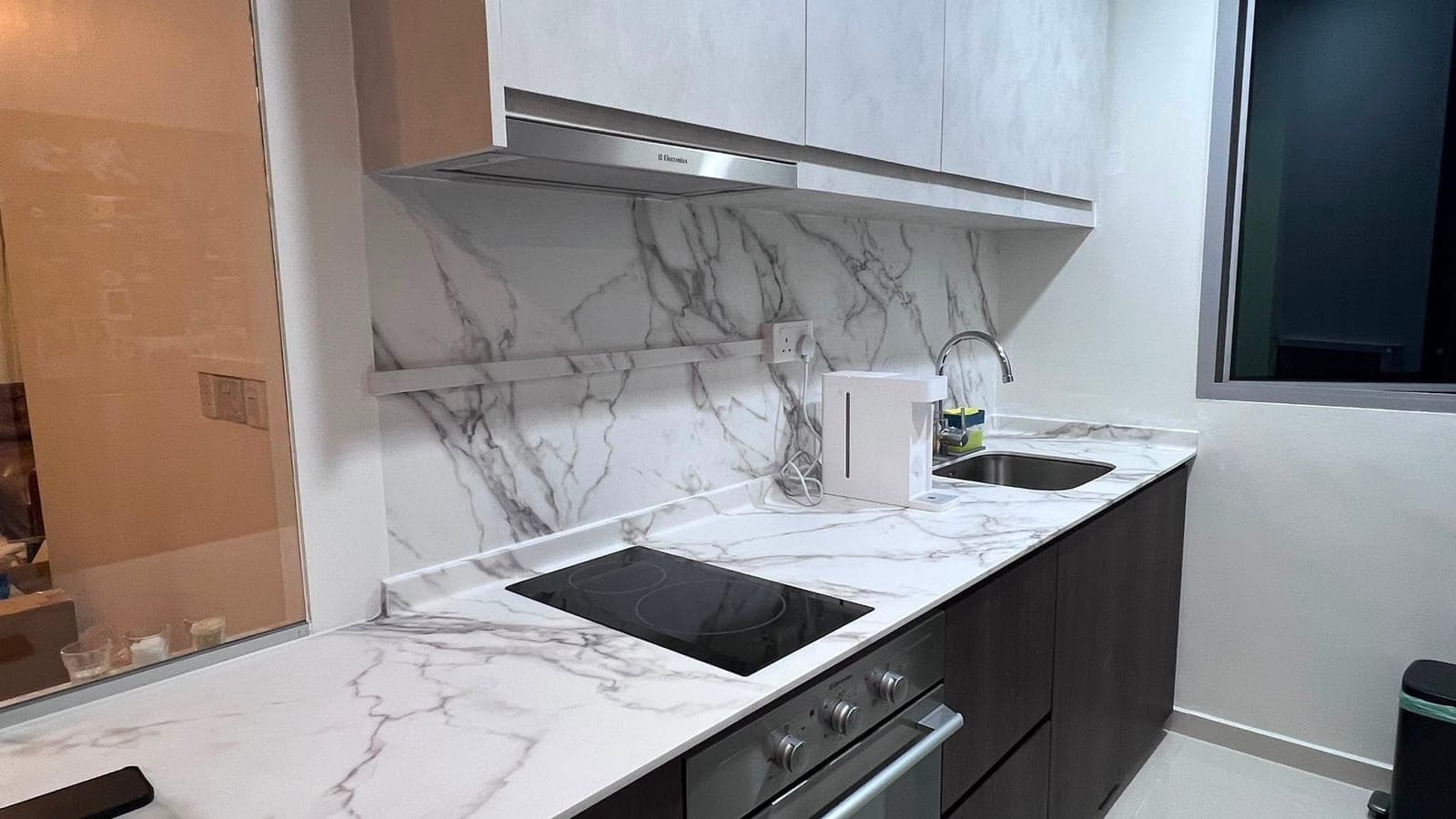 A kitchen in Hougang with a marble-look backsplash, worktop and cabinets
