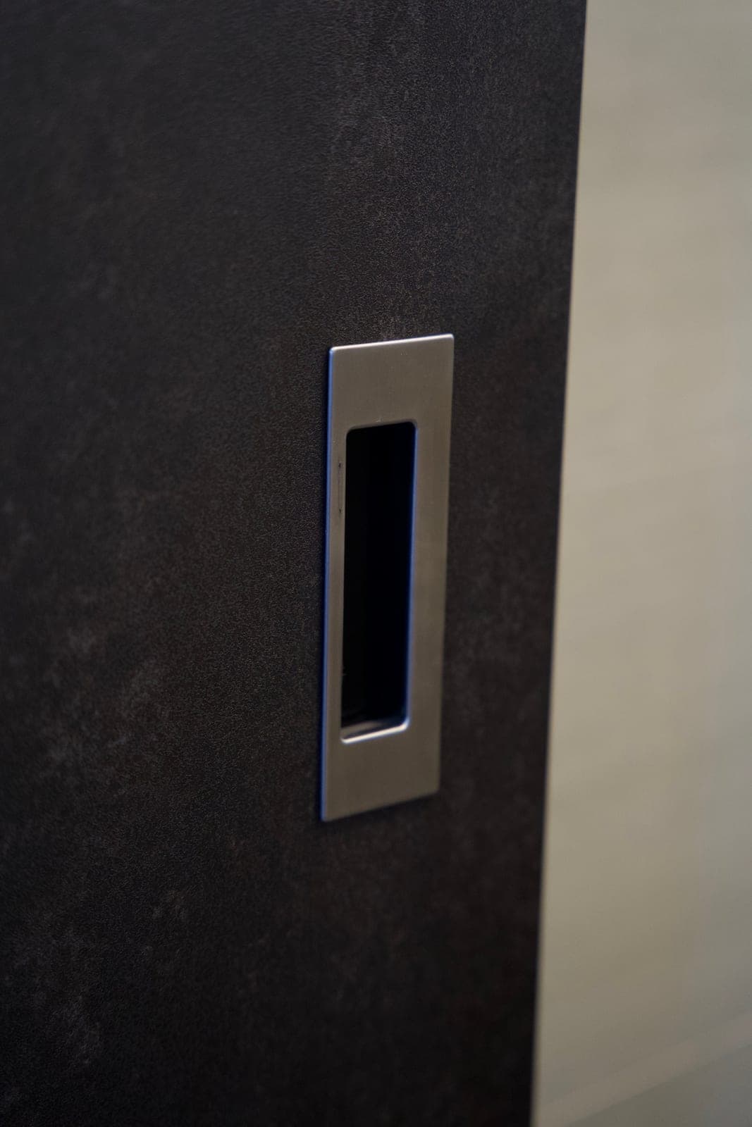 A charcoal stone-look wardrobe panel in Tampines with a recessed pull